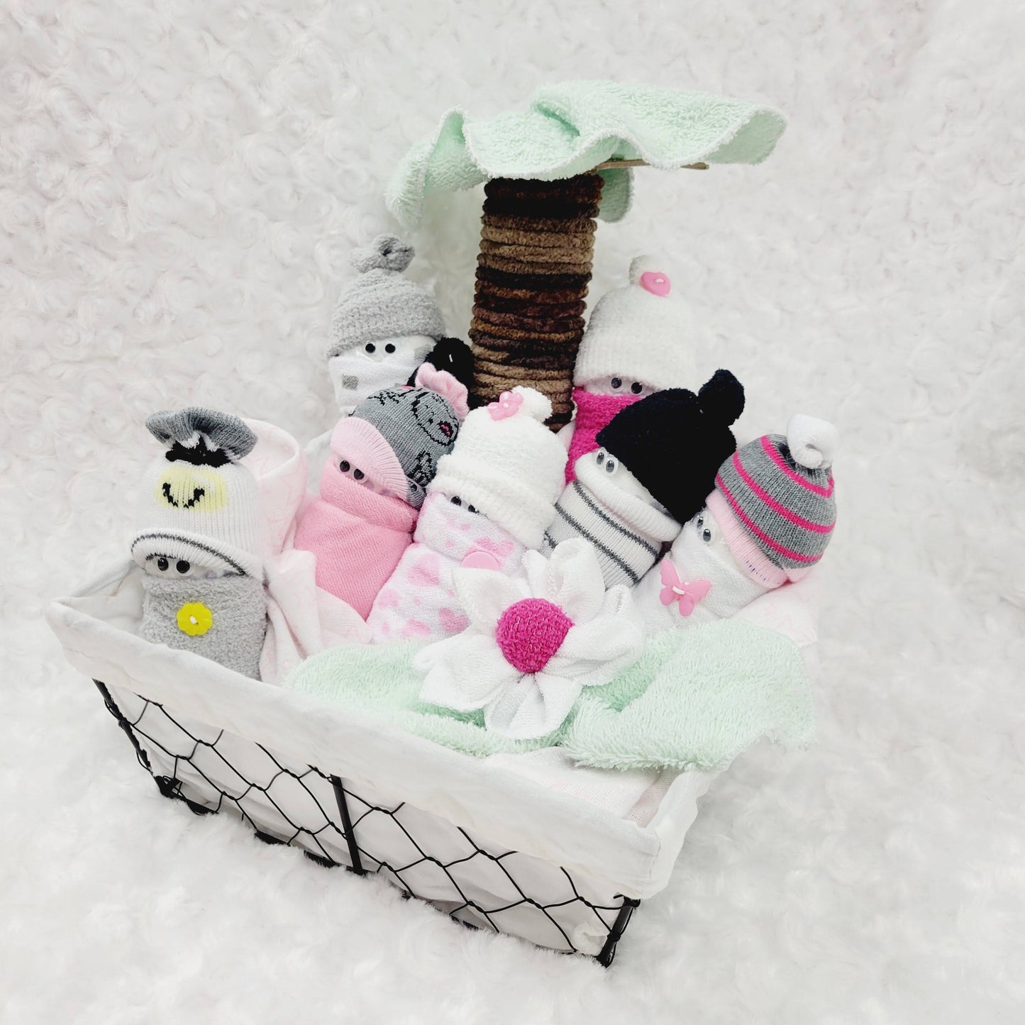 Ensemble cadeau pour babyshower avec des minions fait de couche pour bébé de taille #2 habiller avec des bas de coton et des débarbouillettes, le tout dans un panier avec un palmier fait aussi de débarbouillettes.