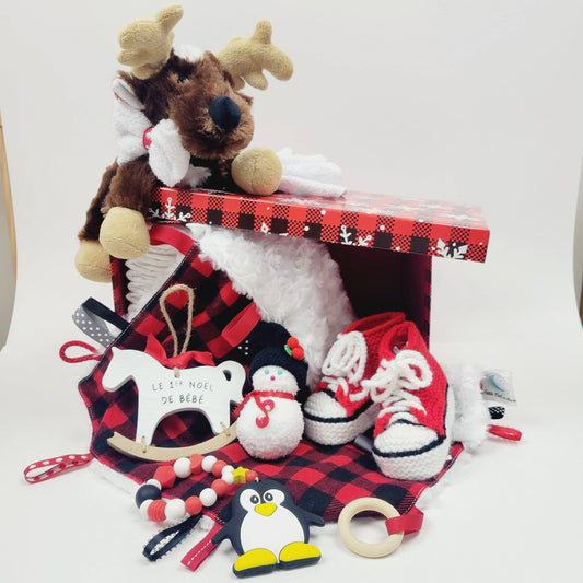 Ensemble cadeau pour noel. Une boite cadeau pour le premier noel de bébé, contenant des couches pour bébé, des pantoufles tricoté rouge, une doudou d'éveil un toutou de cerf.