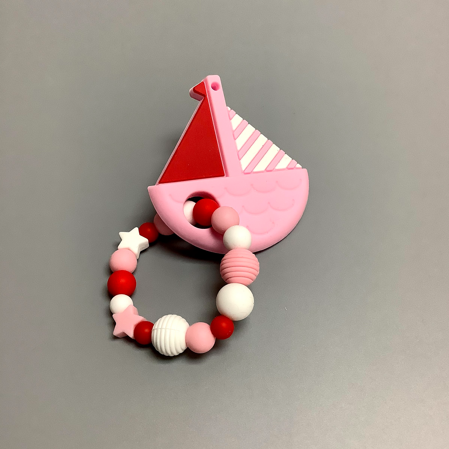 Hochet d'éveil en silicone fait avec plusieurs billes en silicones de différentes couleurs et différentes tailles avec une plus gros jouet de dentition.