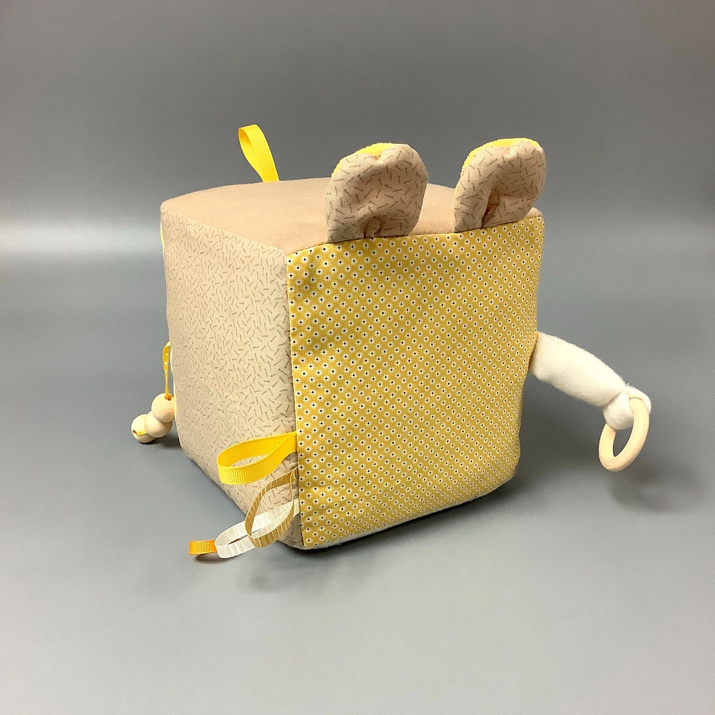 Cube d'éveil pour enfant Fait en coton avec rubans et petits accessoires de bois. Le cube fait du bruit lorsqu'il est agité. Ce produit unique est fait au Québec.