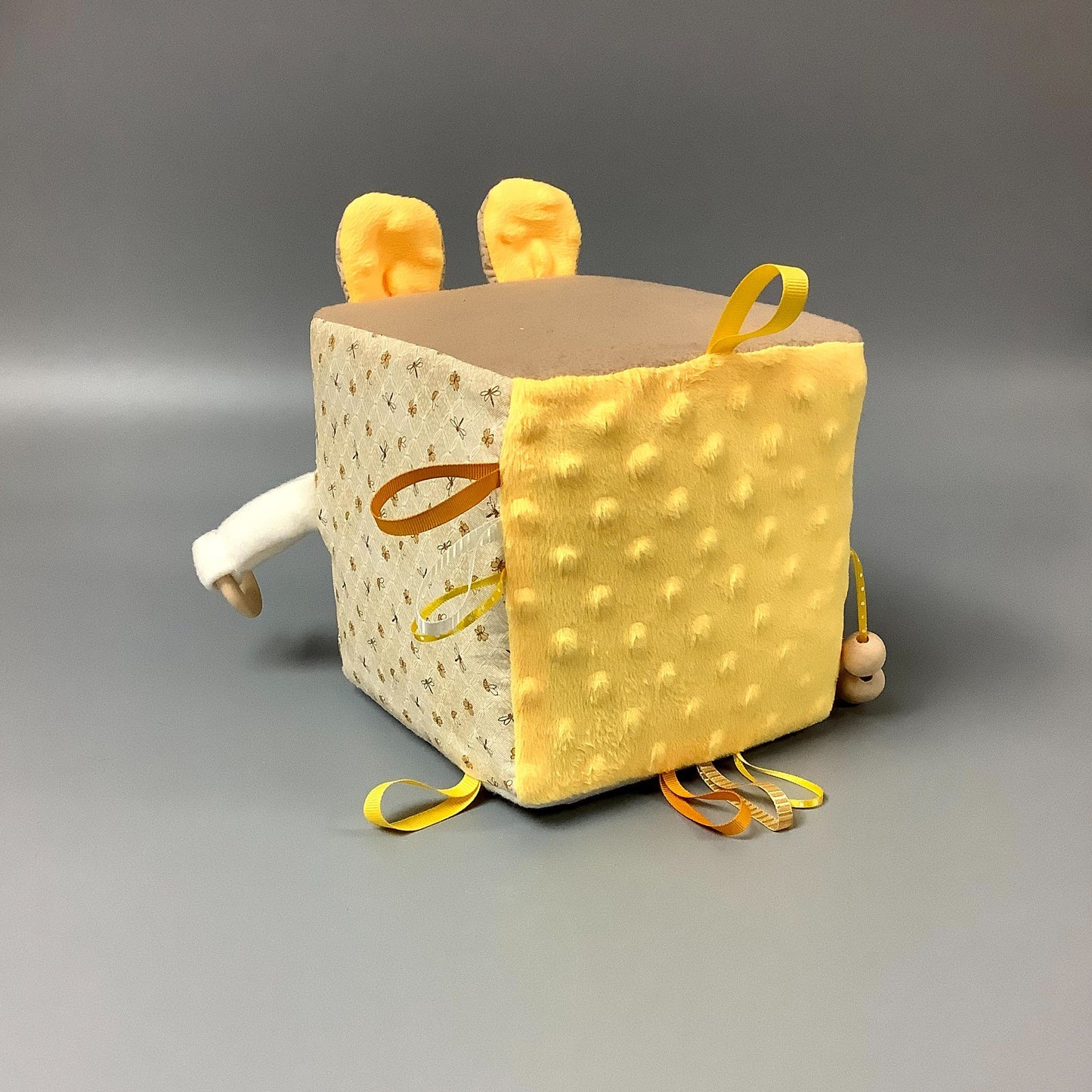 Cube d'éveil pour enfant Fait en coton avec rubans et petits accessoires de bois. Le cube fait du bruit lorsqu'il est agité. Ce produit unique est fait au Québec.