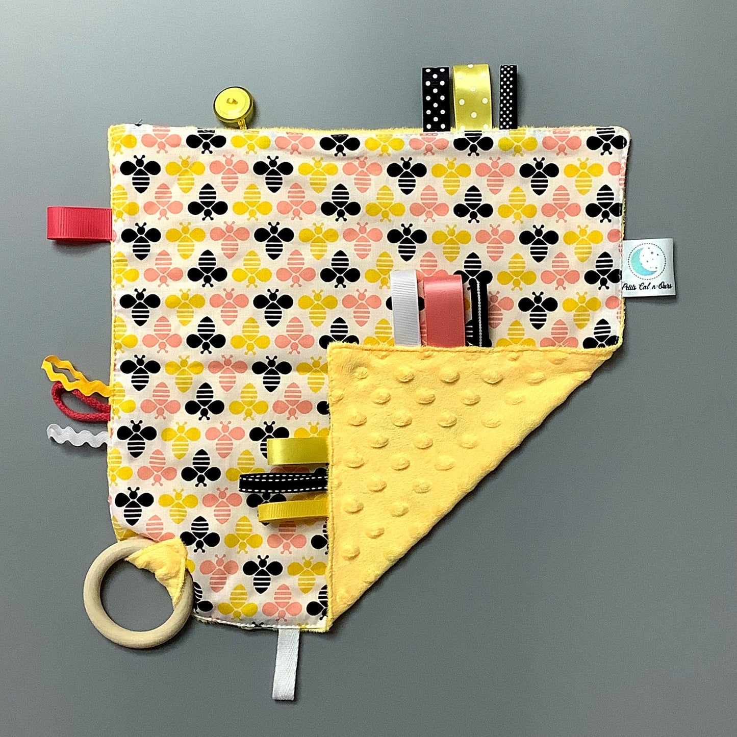 Doudou Calyn pour les enfants Fait en coton et avec du polars flanelle (notre tissu à doudou super doux), avec différents rubans. Chaque doudou est fait au Québec et est unique. Doudou : 12'' x 12''