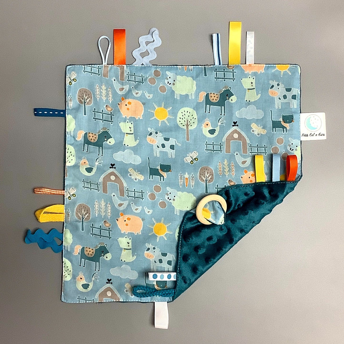 Doudou Calyn pour les enfants Fait en coton et avec du polars flanelle (notre tissu à doudou super doux), avec différents rubans. Chaque doudou est fait au Québec et est unique. Doudou : 12'' x 12''