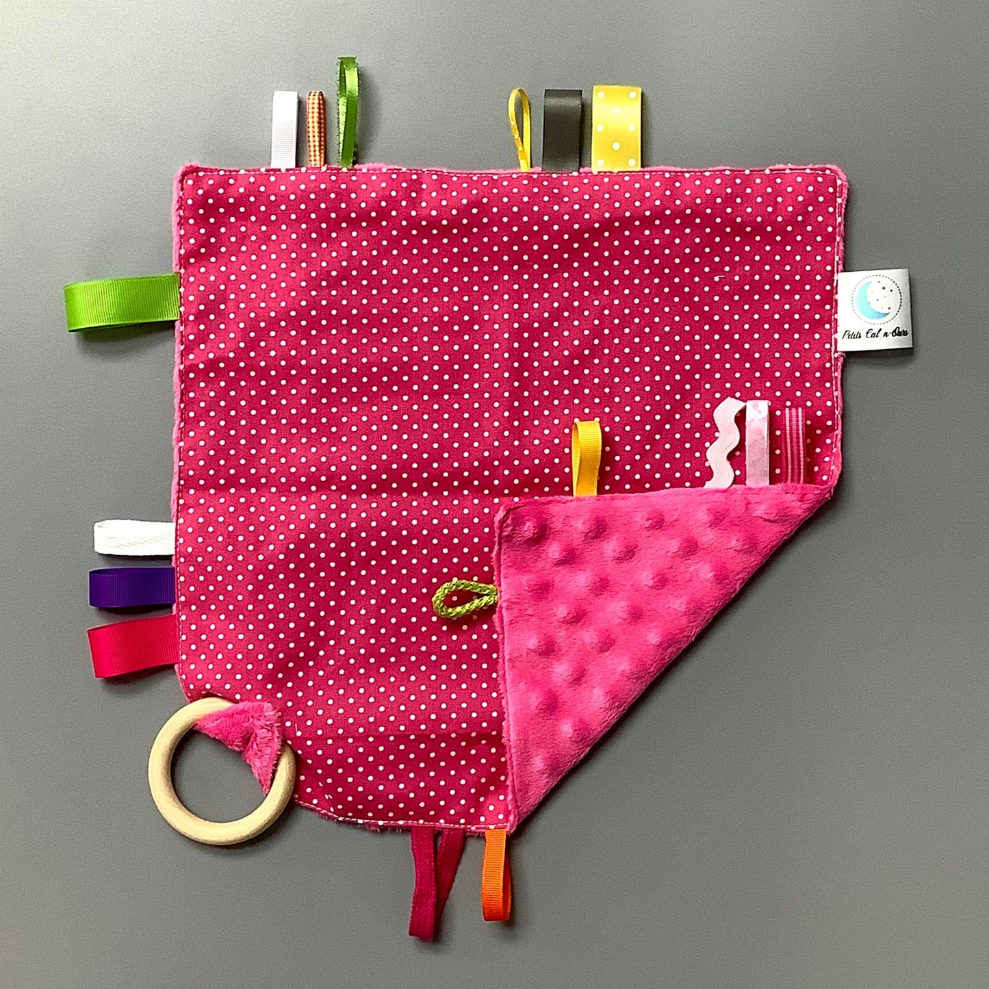 Doudou Calyn pour les enfants Fait en coton et avec du polars flanelle (notre tissu à doudou super doux), avec différents rubans. Chaque doudou est fait au Québec et est unique. Doudou : 12'' x 12''