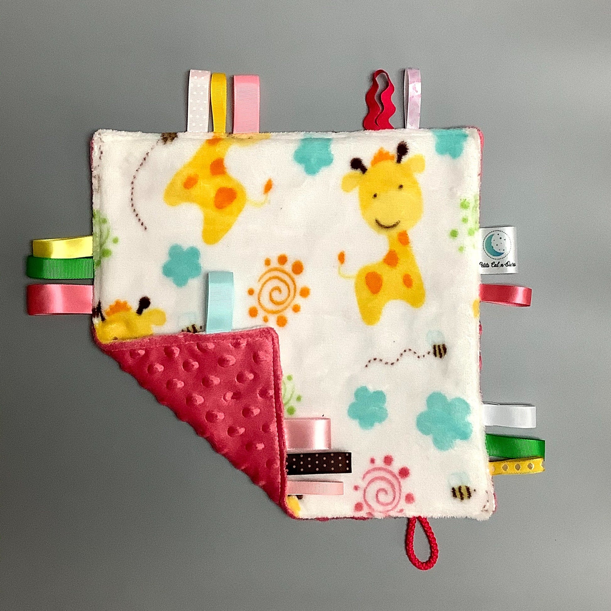 Doudou Calyn  pour les enfants   Fait en coton et avec du polars flanelle (notre tissu à doudou super doux), avec différents rubans.   Chaque doudou est fait au Québec et est unique.   Doudou : 12'' x 12''