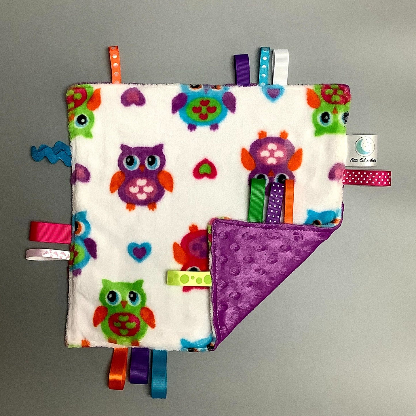 Doudou Calyn  pour les enfants   Fait en coton et avec du polars flanelle (notre tissu à doudou super doux), avec différents rubans.   Chaque doudou est fait au Québec et est unique.   Doudou : 12'' x 12''