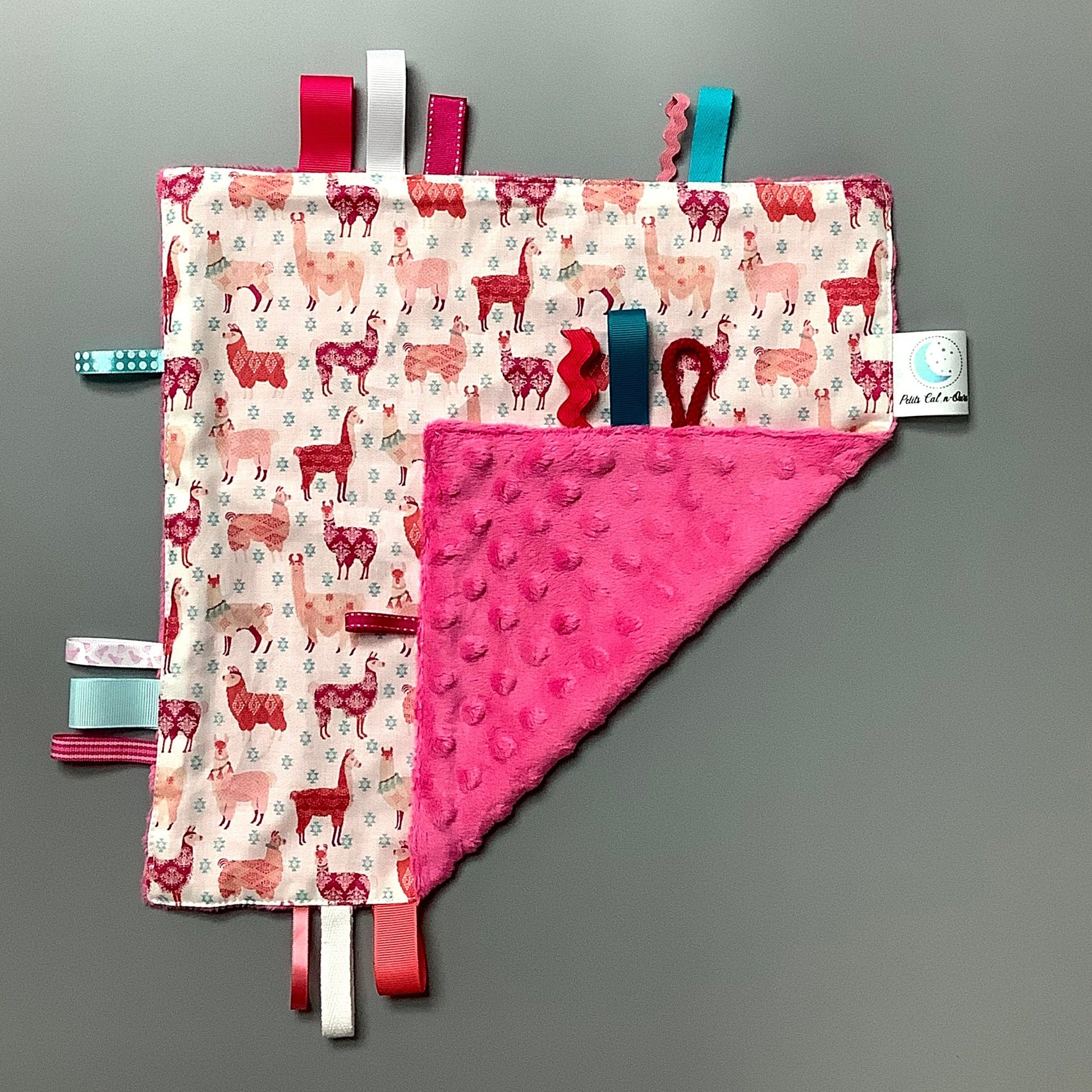 Doudou Calyn  pour les enfants   Fait en coton et avec du polars flanelle (notre tissu à doudou super doux), avec différents rubans.   Chaque doudou est fait au Québec et est unique.   Doudou : 12'' x 12''