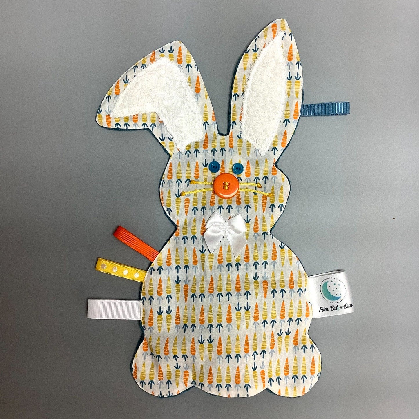 Doudou Calyn pour les enfants Fait en coton et avec du polars flanelle (notre tissu à doudou super doux), avec différents rubans. Chaque doudou est fait au Québec et est unique.