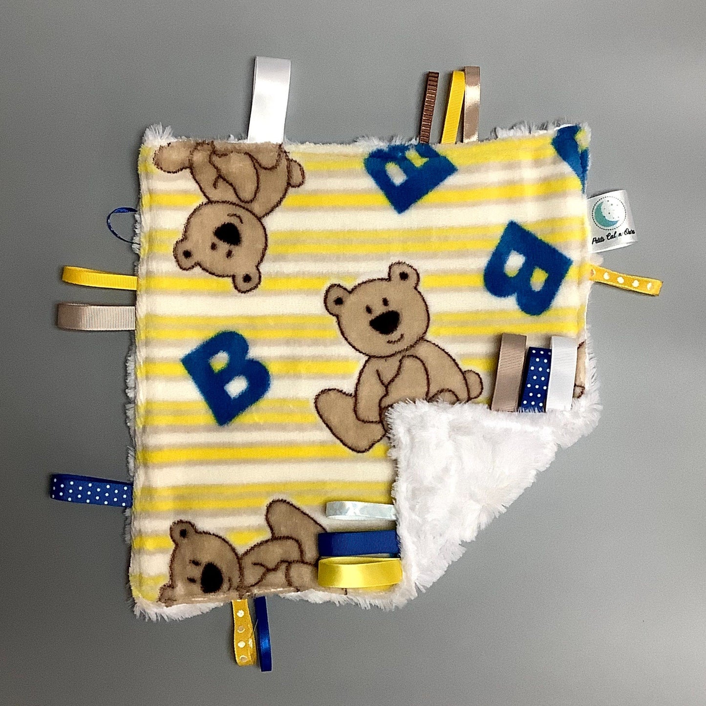 Doudou Calyn  pour les enfants   Fait en coton et avec du polars flanelle (notre tissu à doudou super doux), avec différents rubans.   Chaque doudou est fait au Québec et est unique.   Doudou : 12'' x 12''