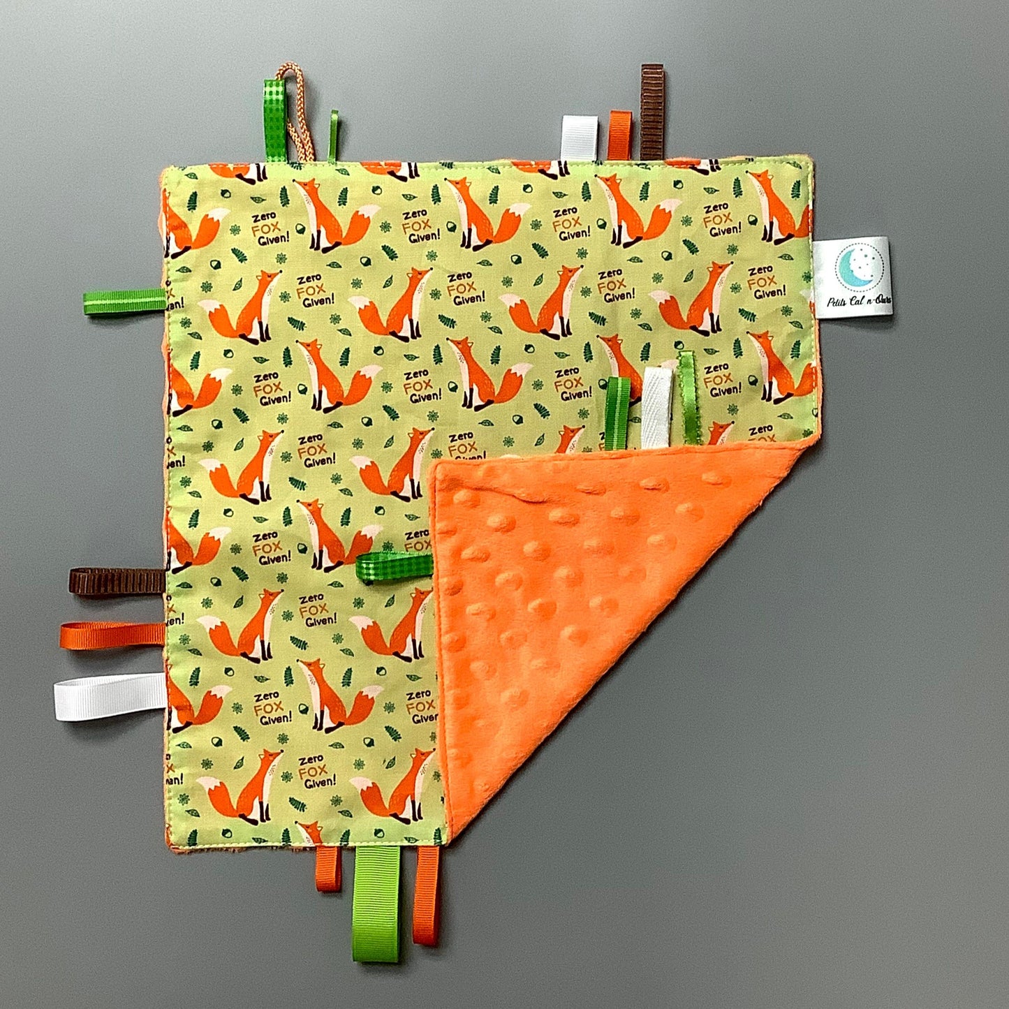Doudou Calyn pour les enfants Fait en coton et avec du polars flanelle (notre tissu à doudou super doux), avec différents rubans. Chaque doudou est fait au Québec et est unique. Doudou : 12'' x 12''