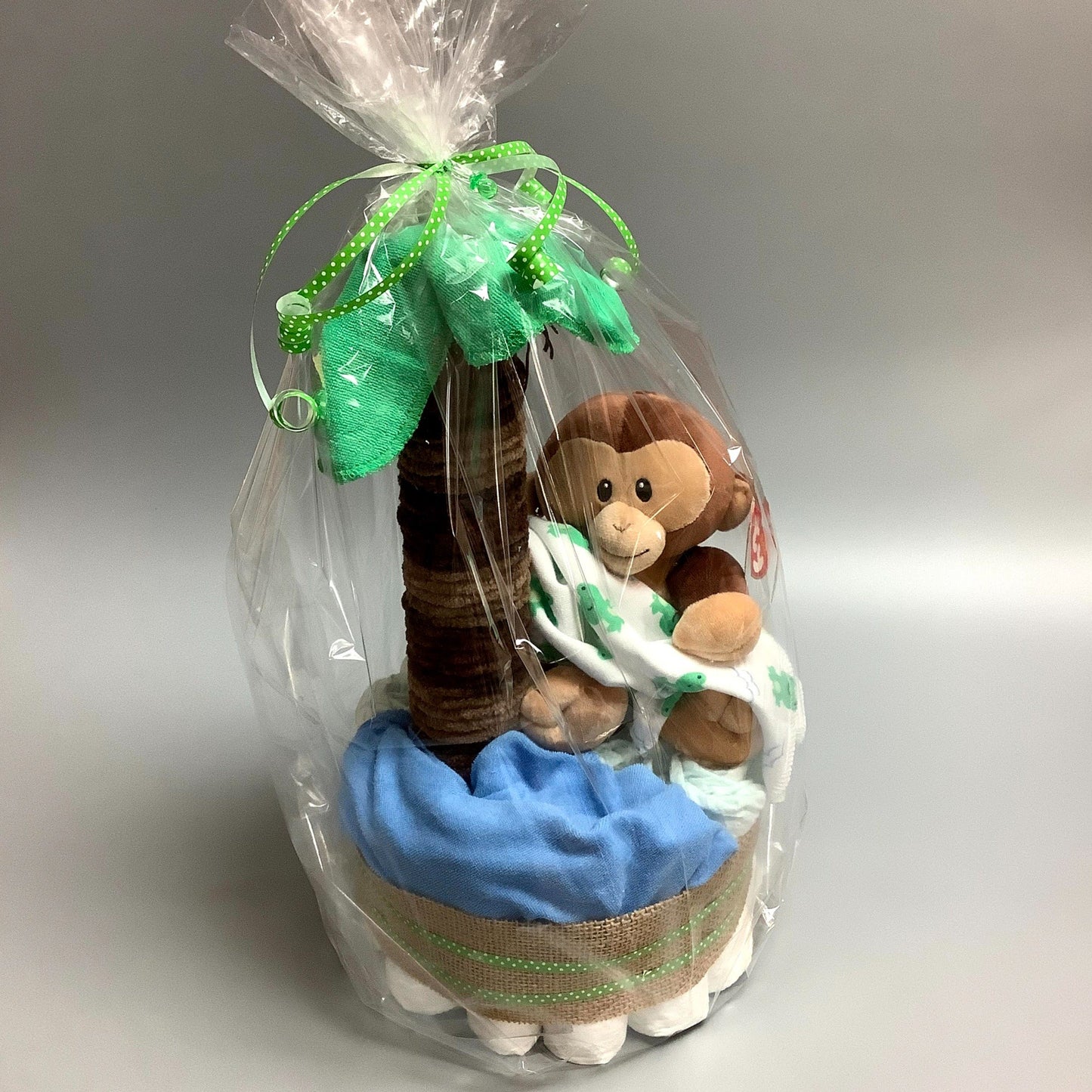 Ce gâteau contient :  - 19 couches (#2)  - 1 toutou de singe - 4 débarbouillettes 8'' x 8''  Ce produit est unique et fait ici au Québec