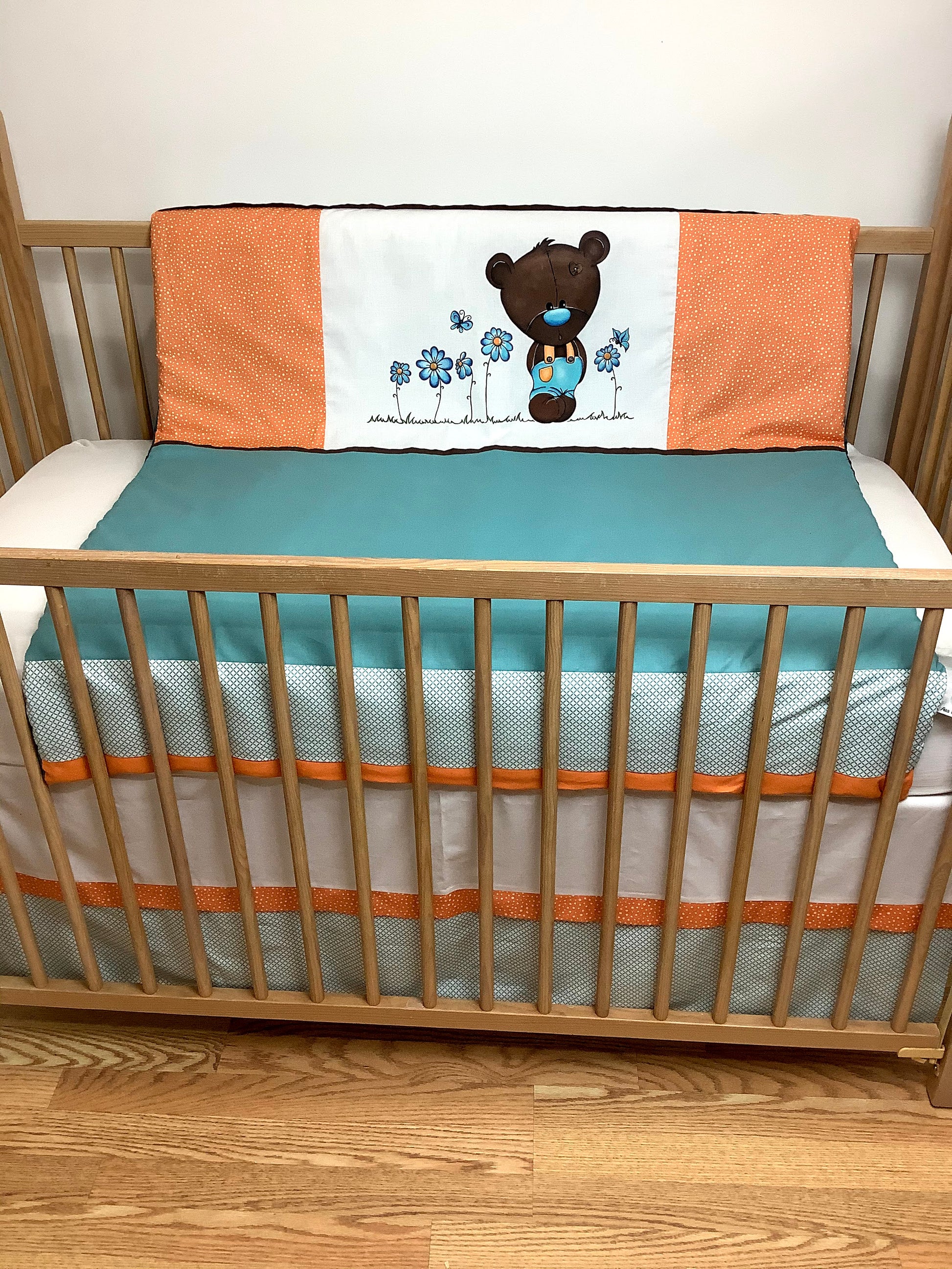 Un joli ensemble 3 morceaux pour le berceau de bébé. Avec de belles couleurs vives, cet ensemble en coton sur le dessus et en Minky en dessous. L'ensemble comprend la douillette, le drap contour et la jupe de lit assortie.   Ce modèle est unique, l'ourson et les fleurs au centre a été peint à la main par notre couturière.   Chaque morceau est fait au Québec et est unique