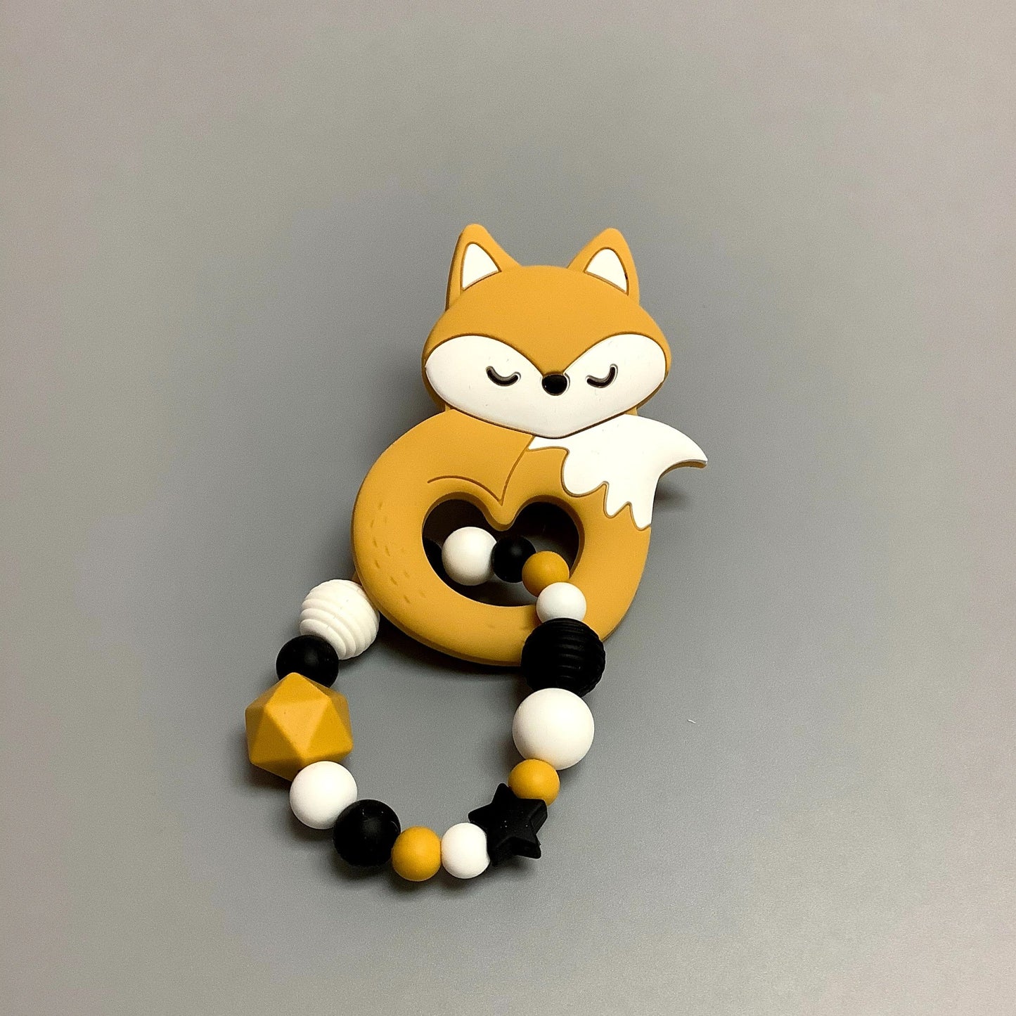 Hochet d'éveil en silicone fait avec plusieurs billes en silicones de différentes couleurs et différentes tailles avec une plus gros jouet de dentition.