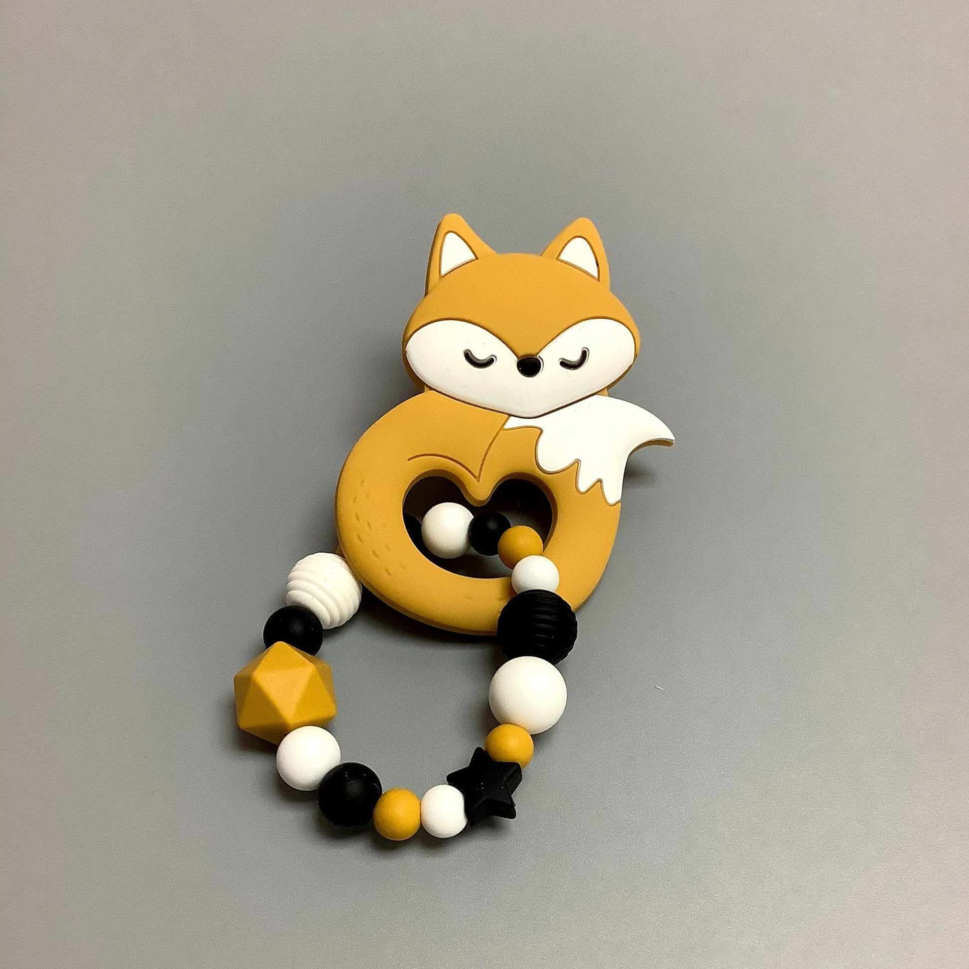 Hochet d'éveil en silicone fait avec plusieurs billes en silicones de différentes couleurs et différentes tailles avec une plus gros jouet de dentition.