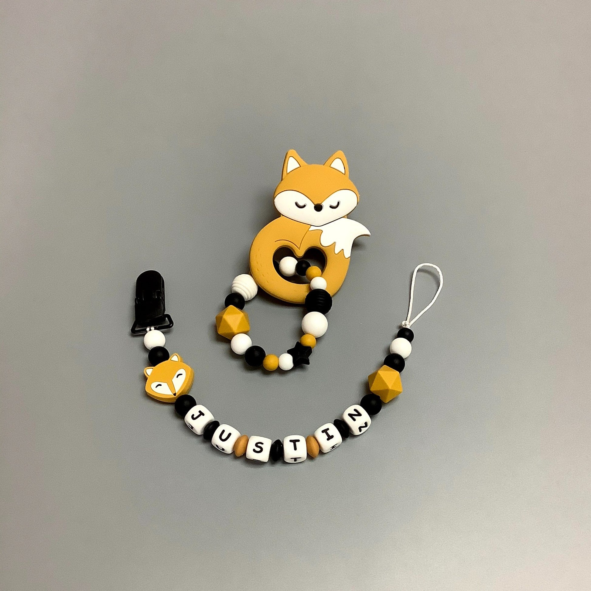 Hochet d'éveil en silicone fait avec plusieurs billes en silicones de différentes couleurs et différentes tailles avec une plus gros jouet de dentition.   Jouet de dentition avec attache-suce fait avec plusieurs billes en silicones de différentes couleurs, tailles et formes, et il est complété par une attache en plastique