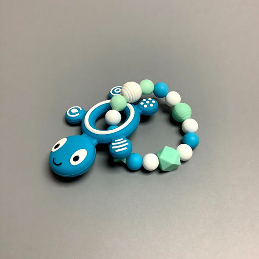 Hochet d'éveil en silicone fait avec plusieurs billes en silicones de différentes couleurs et différentes tailles avec une plus gros jouet de dentition.
