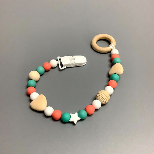 Jouet de dentition avec attache-suce fait avec plusieurs billes en silicones de différentes couleurs, tailles et formes, et il est complété par une attache en plastique.