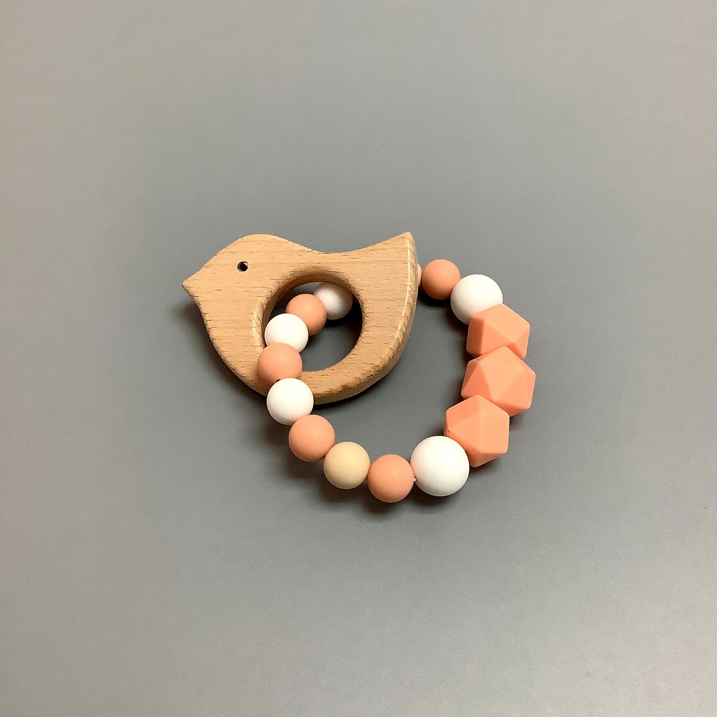 Hochet d'éveil en silicone fait avec plusieurs billes en silicones de différentes couleurs et différentes tailles avec une plus gros jouet de dentition.