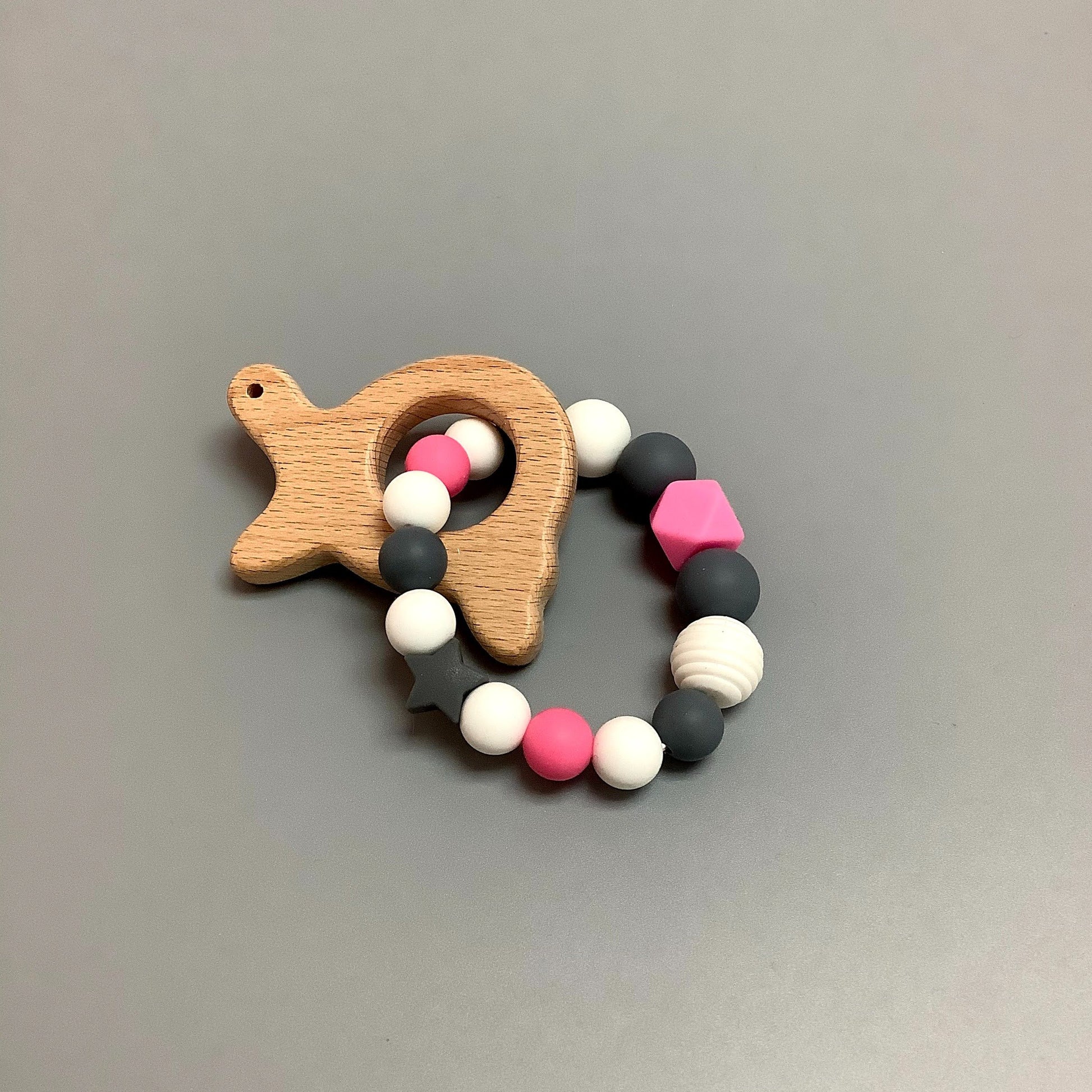 Hochet d'éveil en silicone fait avec plusieurs billes en silicones de différentes couleurs et différentes tailles avec une plus gros jouet de dentition.