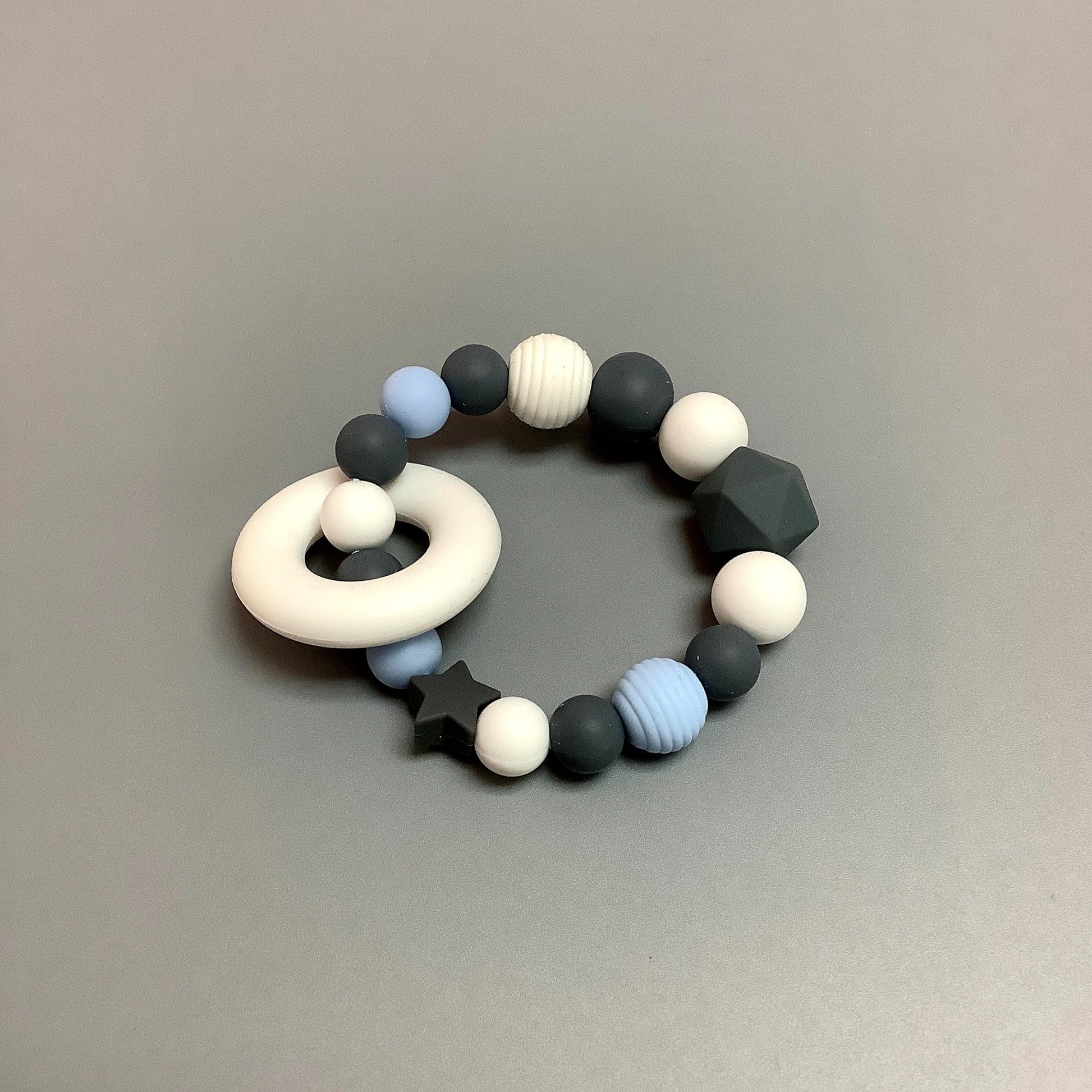 Hochet d'éveil en silicone fait avec plusieurs billes en silicones de différentes couleurs et différentes tailles avec une plus gros jouet de dentition.