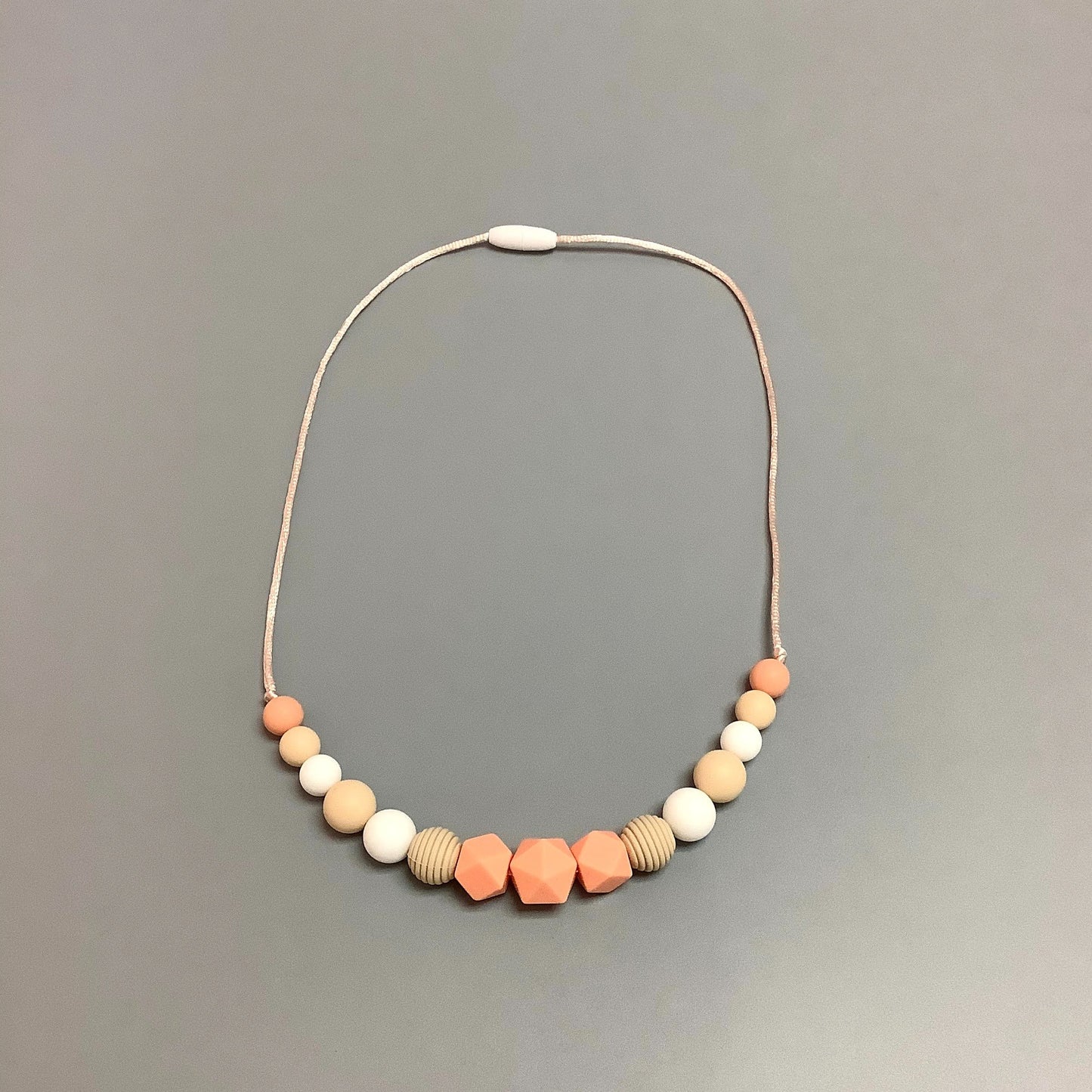 Collier en silicone fait avec plusieurs billes en silicones de différentes couleurs, tailles et formes, et il est complété par une attache en plastique.