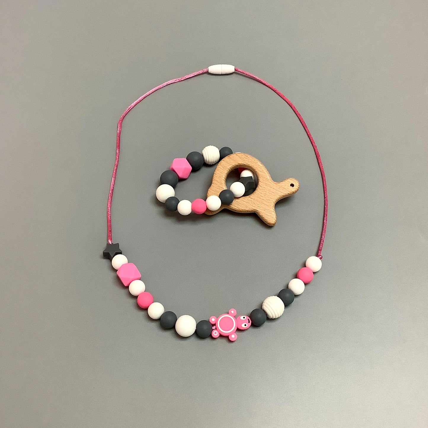 Collier en silicone fait avec plusieurs billes en silicones de différentes couleurs, tailles et formes, et il est complété par une attache en plastique.   Hochet d'éveil en silicone fait avec plusieurs billes en silicones de différentes couleurs et différentes tailles avec une plus gros jouet de dentition.