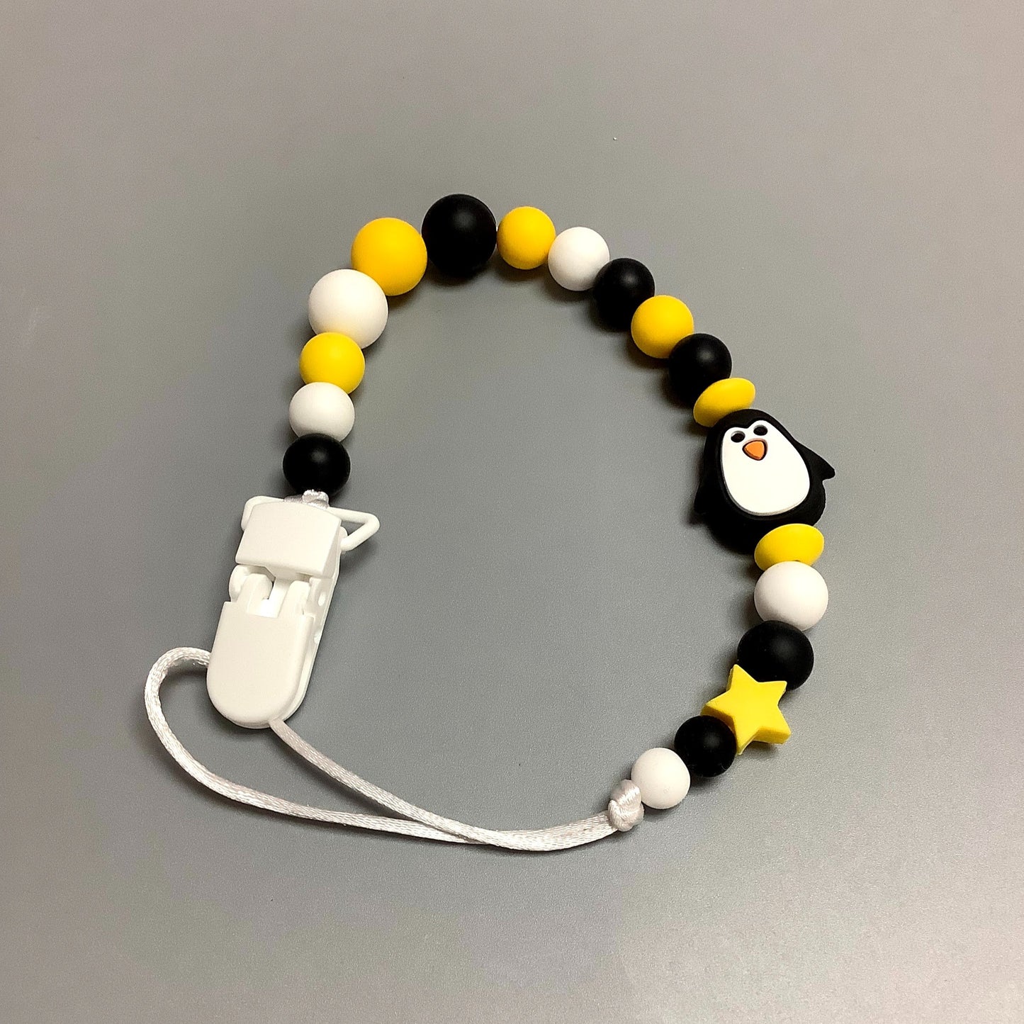 Attache-suce en silicone - Pingouin noir et bille jaune