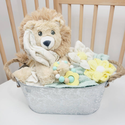 Ensemble cadeau pour babyshower, panier contenant des débarbouillettes en fleur, un toutou de lion avec un jouet de dentition en silicone.