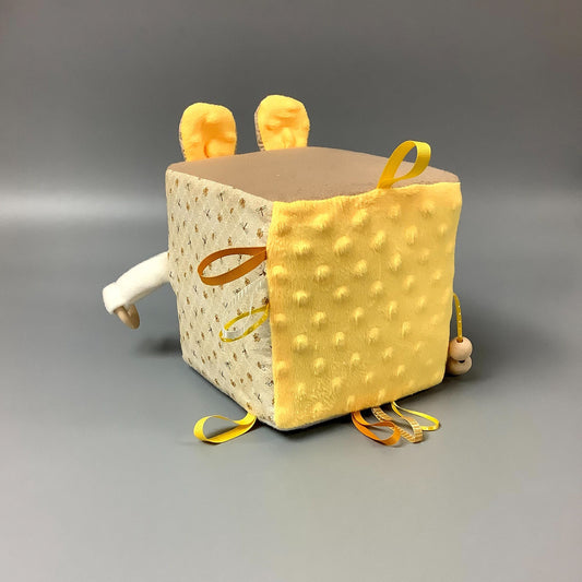 Cube d'éveil pour enfant  Fait en coton avec rubans et petits accessoires de bois. Le cube fait du bruit lorsqu'il est agité.  Ce produit unique est fait au Québec.