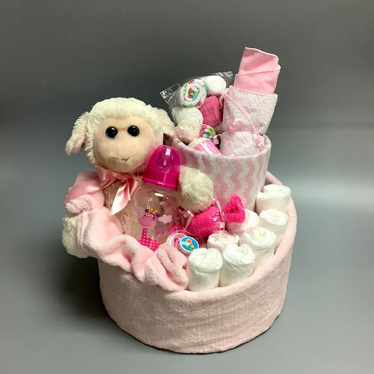 Ce gâteau contient :  - 7 couches (#2)  - 1 bouteille  - 1 suce  - 1 toutou de mouton  - 1 doudou en polars  - 1 doudou en flannelette   - 7 Débarbouillettes  - 2 paires de bas  - 1 bavoir   Ce produit est unique et fait ici au Québec