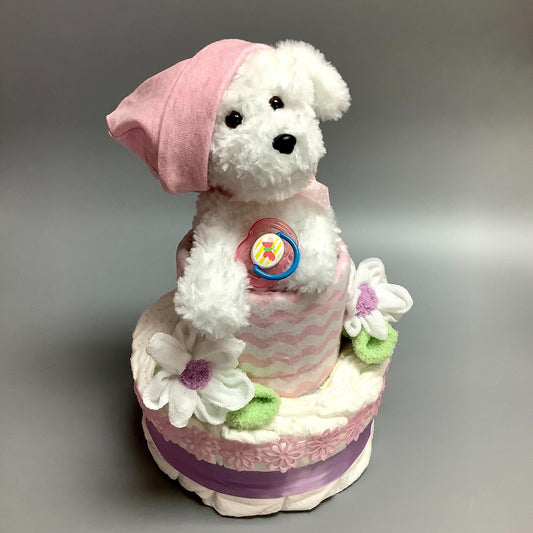 Ce gâteau contient :  - 12 couches (#2)  - 1 suce  - 1 toutou de chien   - 2 Débarbouillettes  - 2 paires de bas  - 1 doudou en flannelette  - 1 bonnet  Ce produit est unique et fait ici au Québec